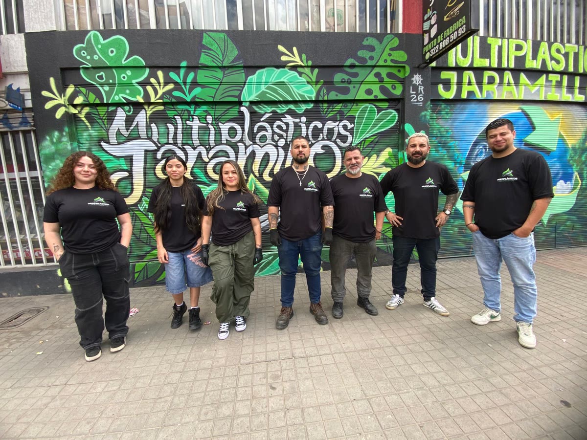El equipo de Multiplásticos Jaramillo, con camiseta de la empresa, frente al mural pintado en la fachada del punto de fábrica